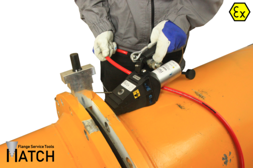 Hydraulic flange spreader (HSW15TEX) on an orange pipe with safety block
