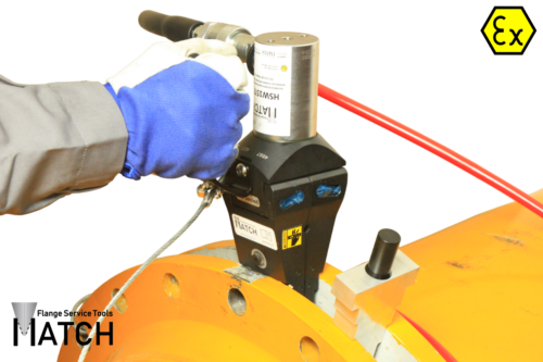 Hydraulic flange spreader (HSW15TEX) in between orange pipes with red Hydraulic hose