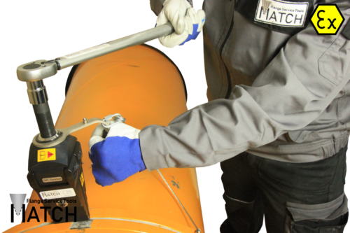 Employee operating the mechanical flange spreader (MSW9TEX) in between orange pipes